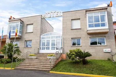a bedroom with a bed and a chair and a window at Motel Punta Cana in Santiago de Compostela
