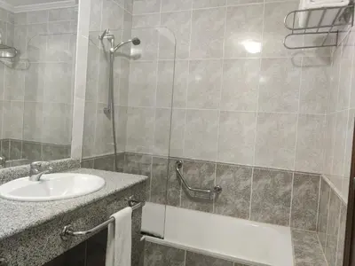a bedroom with a bed and a table and a window at Motel Punta Cana in Santiago de Compostela