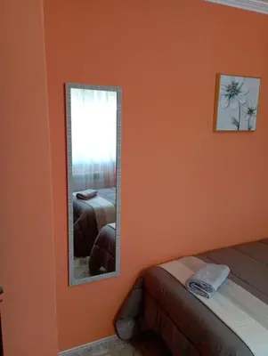 a room with orange walls and a shelf and a table at A Casa do San Paio de Buscás in Ordes