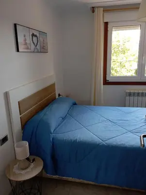 a bedroom with wooden cabinets and a blue bed at A Casa do San Paio de Buscás in Ordes