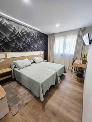 a bedroom with a large bed and a desk at A Quinta de Cea in Cea