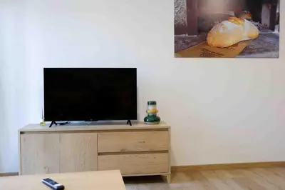 a flat screen tv sitting on top of a wooden cabinet at A Quinta de Cea - Apartamentos in Cea