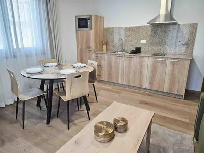 a dining room with a table and a kitchen at A Quinta de Cea - Apartamentos in Cea