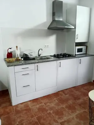 a white kitchen with a sink and a stove at Casa turística Lirio in Chandreja