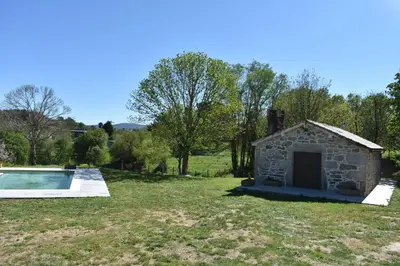 a stone building in a field with a pool at Cabana de Pili in A Estrada