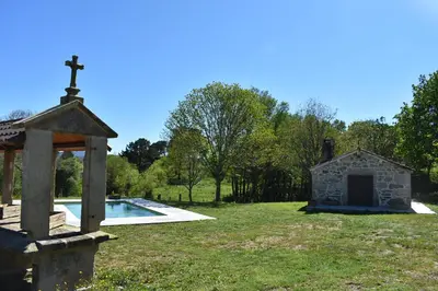 a church with a cross on top of a yard at Cabana de Pili in A Estrada