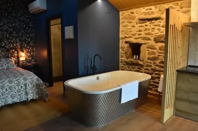 a bathroom with a bath tub next to a bed at Cabana de Pili in A Estrada