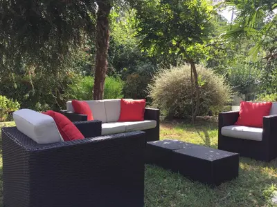 three wicker couches with red pillows in a yard at Agro da Gandarela in Teo