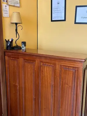 a wooden cabinet with a lamp on top of it at PENSIÓN* AS VIÑAS in Puebla del Brollón