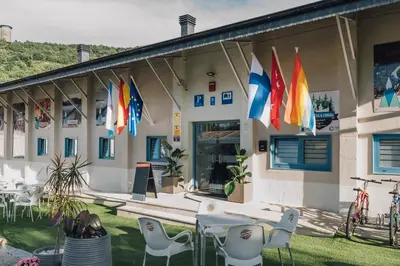 a building with flags on the side of it at Vila Vilariño Albergue Hotel & Restaurante in Ourense