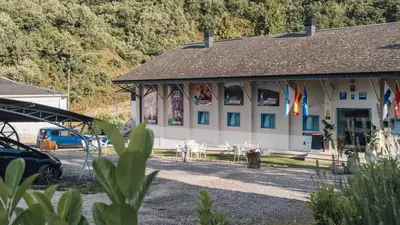 a building with flags on the side of it at Vila Vilariño Albergue Hotel & Restaurante in Ourense