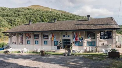 a building with chairs and flags in front of it at Vila Vilariño Albergue Hotel & Restaurante in Ourense