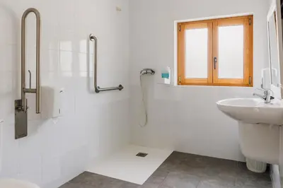 a white bathroom with a sink and a shower at Vila Vilariño Albergue Hotel & Restaurante in Ourense