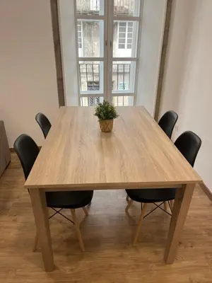 a wooden table with chairs and a potted plant on it at Apartamento con Encanto in Santiago de Compostela