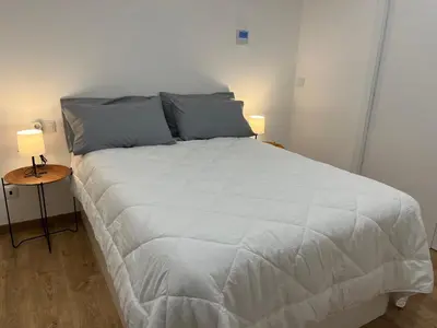a large white bed in a room with two lamps at Apartamento con Encanto in Santiago de Compostela