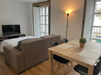 a living room with a couch and a table at Apartamento con Encanto in Santiago de Compostela