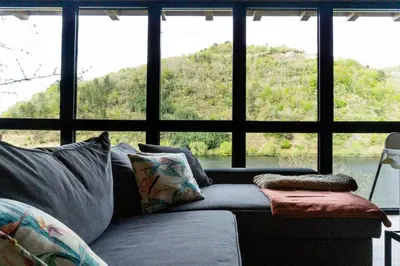 a living room with a couch in front of a window at Ribeira Sacra a Orilla Rio Miño Casas do Pincelo in Pincelo