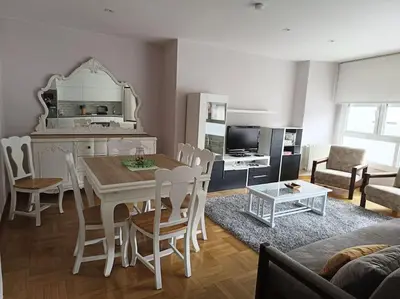 a kitchen and living room with a table and chairs at Vivienda Arias in Carballino