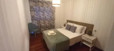 a small bedroom with a bed with a nightstand and a bed sidx sidx sidx at O Portiño de Sigueiro # a 10 min de Santiago in Sigüeiro