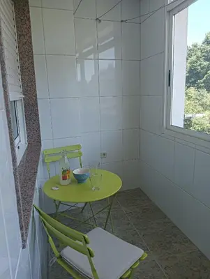 a small green table and chairs in a room at O Portiño de Sigueiro # a 10 min de Santiago in Sigüeiro
