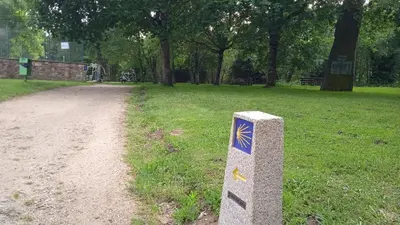 a stone post in a park next to a dirt road at O Portiño de Sigueiro # a 10 min de Santiago in Sigüeiro