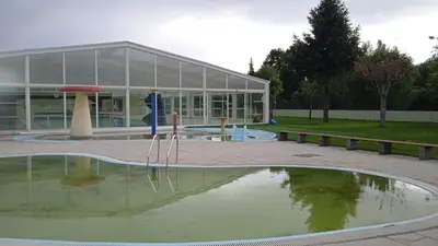 a building with a pool of water in front of a building at O Portiño de Sigueiro # a 10 min de Santiago in Sigüeiro
