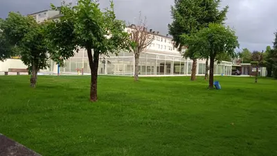 a building in a field with trees in front of it at O Portiño de Sigueiro # a 10 min de Santiago in Sigüeiro