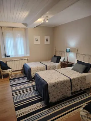 a bedroom with three beds and a table and a couch at Casa Alba in Chan de Vilar