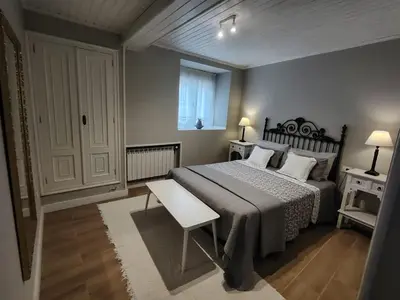 a bedroom with a bed and a table and a window at Casa Alba in Chan de Vilar