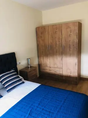 a bedroom with a blue bed and a wooden cabinet at Casa Aricel VT in Chantada