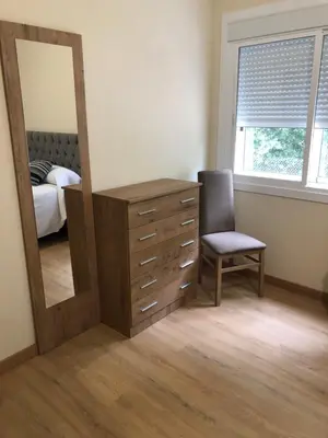 a bedroom with a mirror and a dresser with a chair at Casa Aricel VT in Chantada
