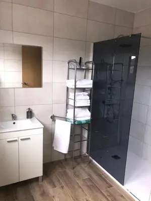 a bathroom with a shower and a sink and towels at Casa Aricel VT in Chantada