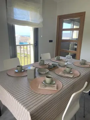 a table with plates and cups on top of it at Apartamento en Barreiros in San Miguel de Reinante