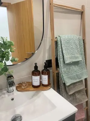 a bathroom sink with a mirror and two bottles on it at Apartamento en Barreiros in San Miguel de Reinante