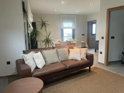 a living room with a brown leather couch with pillows at Apartamento en Barreiros in San Miguel de Reinante