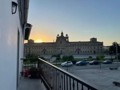 a large building with cars parked in a parking lot at Campo de la Compañía in Monforte de Lemos