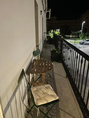 a wooden chair sitting on a balcony at night at Campo de la Compañía in Monforte de Lemos