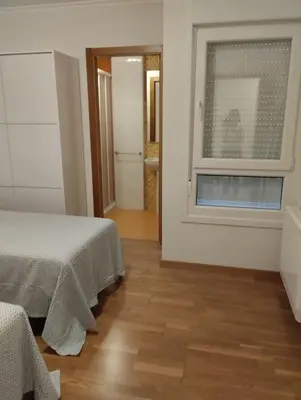 a white room with a bed and a window at ALVAFEr II in Ribadeo