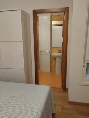 a bedroom with a bed and a bathroom with a sink at ALVAFEr II in Ribadeo