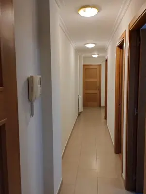 a long hallway with a phone on a wall at ALVAFEr II in Ribadeo