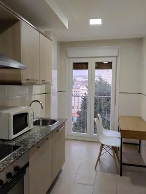 a kitchen with a sink and a microwave and a table at ALVAFEr II in Ribadeo