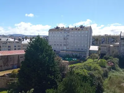 a large building in a city with trees and buildings at ALVAFEr II in Ribadeo
