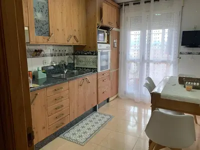 a kitchen with wooden cabinets and a sink at Duplex Casa Camino in Ponferrada