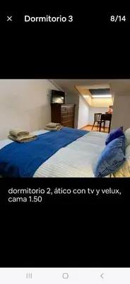 a bedroom with a bed with a blue blanket at Duplex Casa Camino in Ponferrada