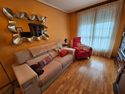 a living room with a couch and a mirror at Duplex Casa Camino in Ponferrada