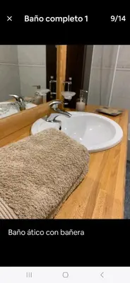 a bathroom sink with a rug on a wooden counter at Duplex Casa Camino in Ponferrada