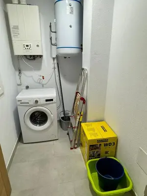 a laundry room with a washing machine and a washer at Cortiñas in Villalba