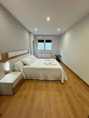 a bedroom with two beds and a wooden floor at Cortiñas in Villalba