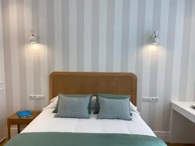 a bedroom with a bed with blue and white stripes at oh la life! at the top in Santiago de Compostela
