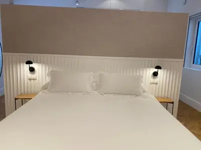 a white bed with two pillows on top of it at oh la life! at the top in Santiago de Compostela